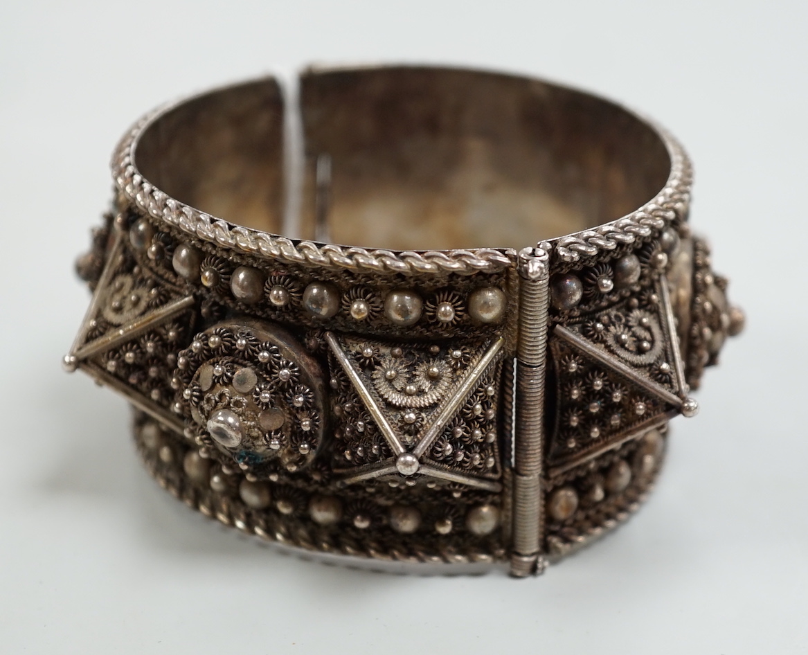 A Middle Eastern white metal hinged bangle.